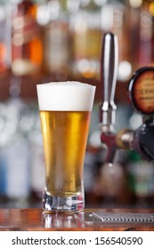 Schooner Glass Of Ice Cold Beer Sitting On Bar Top Near Beer Pouring Tap