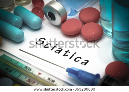 Sciatica - diagnosis written on a white piece of paper. Syringe and vaccine with drugs.