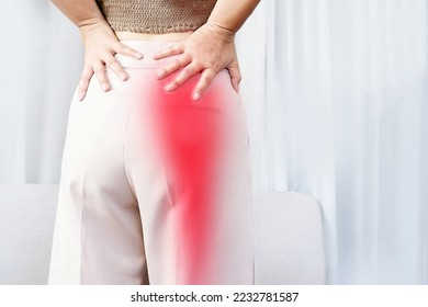 Sciatica Pain concept with woman suffering from buttock pain spreading to down leg  - Shutterstock ID 2232781587