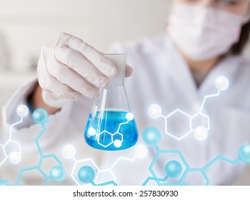 Science, Chemistry, Biology, Medicine And People Concept - Close Up Of Young Female Scientist With Flask Making Test Or Research In Clinical Laboratory