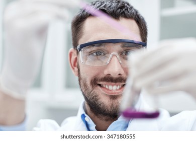 science, chemistry, technology, biology and people concept - young scientist mixing reagents from glass flasks and making test or research in clinical laboratory