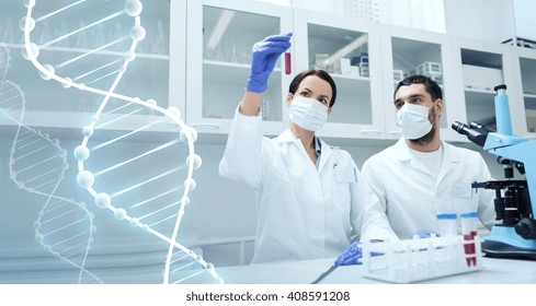 Science, Chemistry, Technology, Biology And People Concept - Young Scientists With Test Tube And Microscope Making Research In Clinical Laboratory