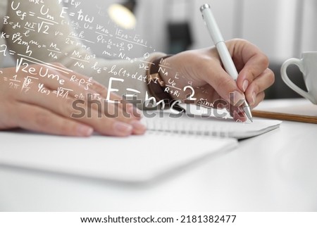 Science and education concept. Illustration of basic physics and mathematics formulas and woman working at table, closeup