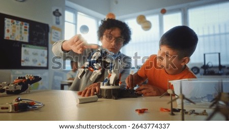 Science and Engineering Lesson: Elementary School Student Studying Model of Innovative Robotic Arm. Teacher Educating Smart Young Boy in Modern Classroom. Interactive Learning and STEM Education.