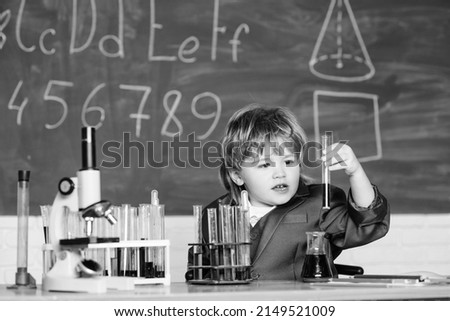 Similar – Image, Stock Photo Serious little boy playing with chemical liquids