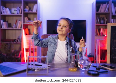 Science, hobbies, learning, education, discovery, childhood and domestic life. Focused Caucasian little girl doing chemistry experiment looking at test tube in evening at living room. - Powered by Shutterstock