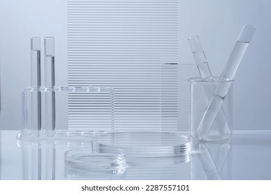 Science and medical background with transparent round podium, lab glassware filled colorless liquid and ribbed acrylic sheets decorated on white background. Space for products presentation