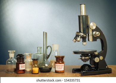 Science microscope and old laboratory glass on table vintage photo