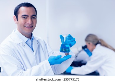 Science Student Holding Blue Chemical In Beaker At The University