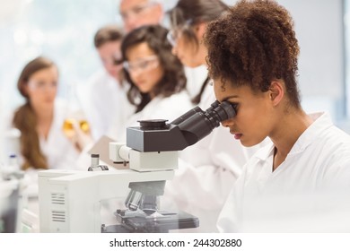 Science student looking through microscope in the lab at the university - Powered by Shutterstock