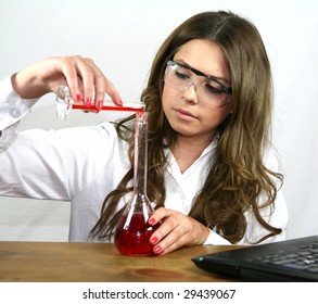 A science student pours a red solution