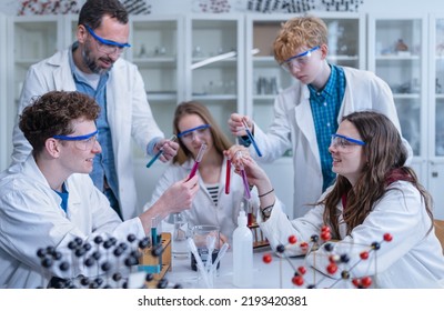 Science students with teacher doing chemical reaction experiment in the laboratory at university. Low angle view. - Powered by Shutterstock