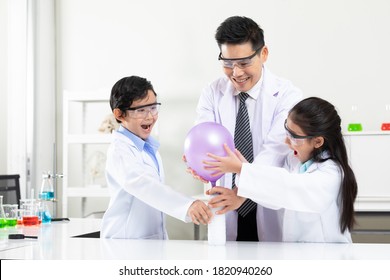 Science Teacher Doing Or Testing Balloon Blow Up Experiment From Bottle With Child Students