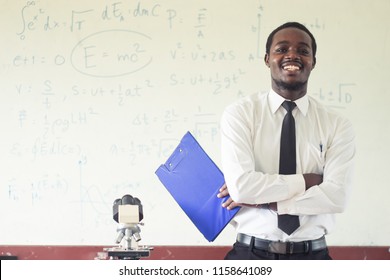 science teacher smiling in the classroom with microscope.