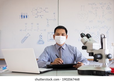 Science Teacher Wearing Mask And   Teaching In The Classroom