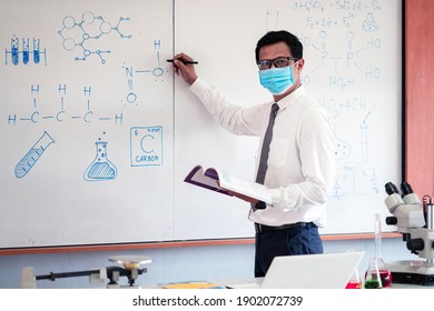 Science Teacher Wearing Mask And   Teaching In The Classroom