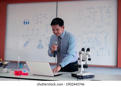 Science Teacher Wearing Mask And   Teaching Online With Laptop In The Classroom