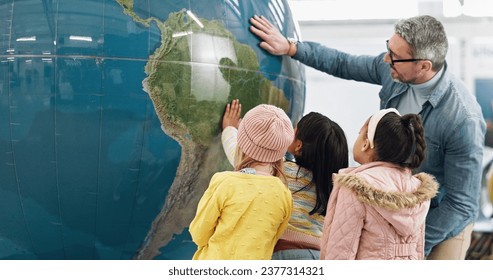 Science, world and students learning about the earth with a teacher at school for growth or development. Geography, globe or planet with a man teaching kids about climate change or global warming - Powered by Shutterstock