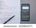 scientific calculator next to a notebook with math calculations. Counting integrals