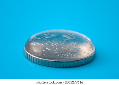 Demostración científica y concepto de tensión superficial con agua sobre la moneda metálica aislada sobre fondo azul