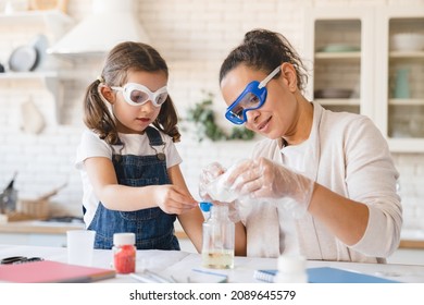 Scientific experiment at home  Laboratory tests for school homework  Parent mother and daughter kid making chemical test at home kitchen  Nanny babysitter teacher help in protective glasses