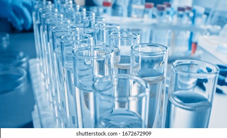 Scientific Laboratory: Pipette Dropping Liquid into Test Tubes, Medical Research and Analysis. Moving Pharmaceutical Production Line; Dropper Fills Sample Tubes used for DNA Study. Close-up Macro