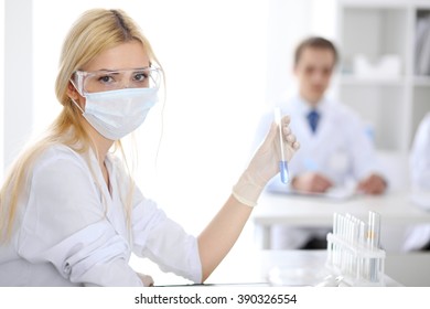Scientific research team with clear solution in laboratory - Shutterstock ID 390326554
