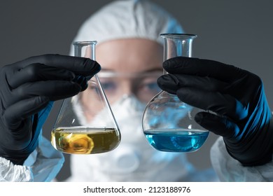 Scientific virologist. Test tubes in doctor hand. Test tubes with dangerous viruses concept. Medicine and antidote in doctor hands. Virus University employee. Biologist in protective suit and gloves.