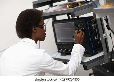 Scientist african american woman working in laboratory with oscillograph. Research and development of electronic devices by color black woman.