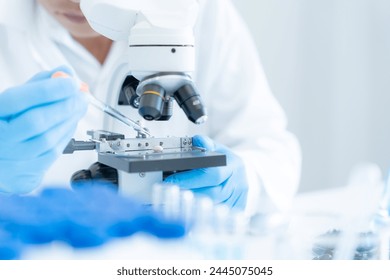 Scientist analyze biochemical samples in advanced scientific laboratory. Medical professional use microscope look microbiological developmental of viral. Biotechnology research in science lab. - Powered by Shutterstock