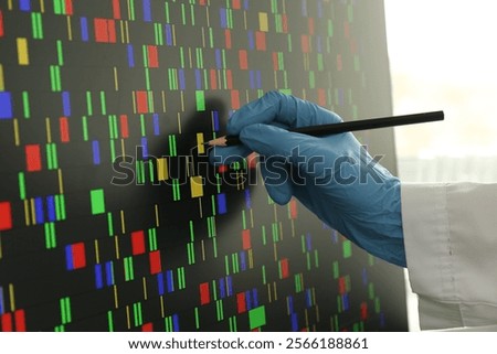 Scientist analyzing DNA data in laboratory, closeup