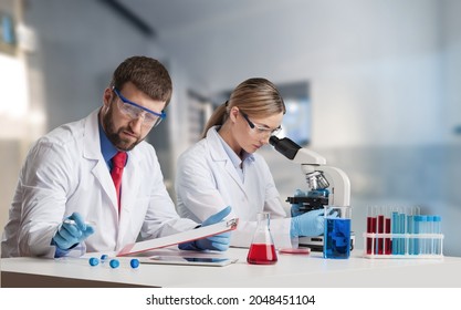 Scientist Analyzing Microscope Slide At Laboratory, A Biopsy In The Laboratory Of Cancer Research