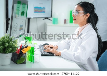 Scientist analyzing sustainability data on a digital dashboard labtop in a modern laboratory, developing green energy solutions, supporting climate action, net zero goals, and eco-friendly innovation.