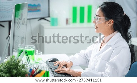 Scientist analyzing sustainability data on a digital dashboard labtop in a modern laboratory, developing green energy solutions, supporting climate action, net zero goals, and eco-friendly innovation.