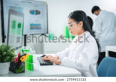 Scientist analyzing sustainability data on a digital dashboard labtop in a modern laboratory, developing green energy solutions, supporting climate action, net zero goals, and eco-friendly innovation.