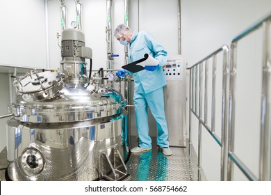 scientist in blue lab suit working with control panel, look at camera