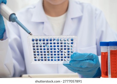 Scientist with cell culture in sample micro plate for research in science laboratory.