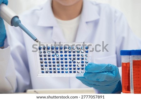 Scientist with cell culture in sample micro plate for research in science laboratory.