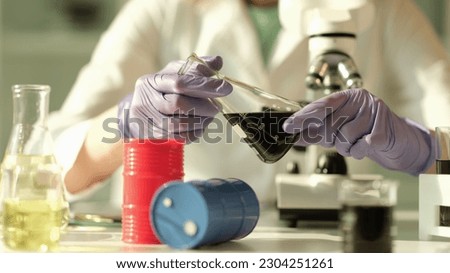 Scientist chemist holding in his hands flask with oil in chemical laboratory closeup