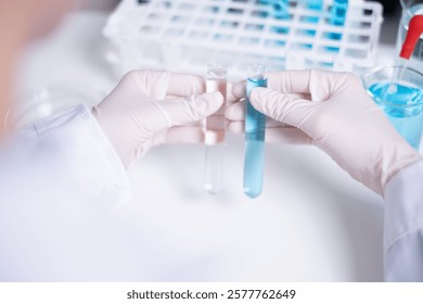 Scientist compare difference between two test tubes laboratory science research chemistry chemical liquid medical research experiment examining technician healthcare and medicine analyzing biology