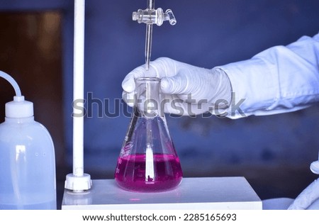The scientist is conducting an acid-base titration in the lab, measuring precisely the amount of acid or base needed to neutralize a solution. Accurate results are critical in this chemical process.