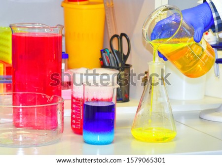 The scientist conducts demonstration experiments with solutions of various substances with the addition of dry ice, dye. The phenomenon of fluorescence.