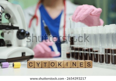 A scientist conducts experiments using test tubes and a microscope, studying cytokines to understand health conditions