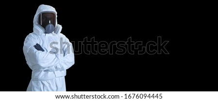 scientist in coronavirus protection suit. man in a protective suit and mask.  paramedic in full biosecurity suit isolated on black background. doctor in personal protective equipment suit
