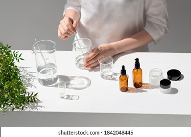 The scientist, dermatologist testing the organic natural cosmetic product in the laboratory. Vials, glass laboratory flasks. Beauty cosmetic research and development concept.