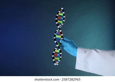 Scientist with DNA structure model on dark blue background, closeup