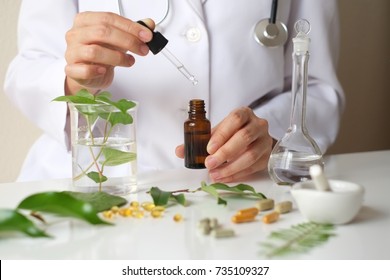 Scientist Or Doctor Making Alternative Medicine Herb , Mortar, Laboratory Glassware, Plant In Tube, Flower , On White Background.