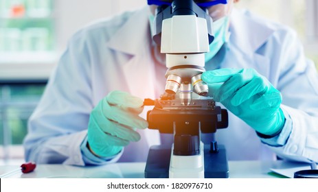 Scientist Or Doctor Use Microscope To Test For The Coronavirus (COVID 19). Or A New Flu Virus To Save People Life In The Lab Or Hospital. Success In Research The Treatment Of Patient