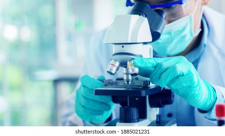 Scientist or doctor use microscope to test for the coronavirus (COVID 19). Or a new flu virus to save people life In the lab Or hospital. Success in research the treatment of patient