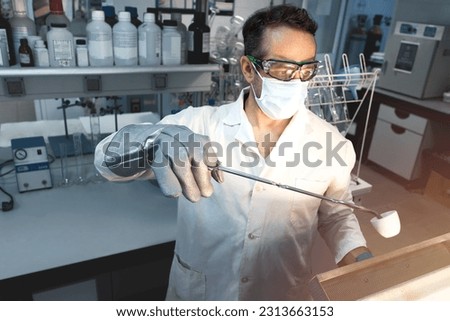 Scientist doing a test in a laboratory muffle in which a sample is calcined in a ceramic crucible. Selective focus